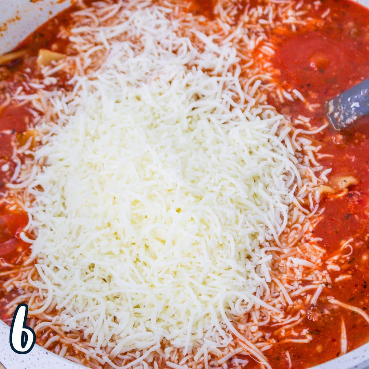 Cheese added to a pot of lasagna soup in a large pot. 