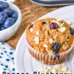 A banana blueberry oatmeal muffin on a white plate, with a bowl of blueberries in the background. Text: "Delight in these homemade Banana Blueberry Oatmeal Muffins.