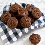 Chocolate Espresso Muffins with chocolate chips in a basket lined with a blue and white checkered cloth.