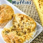 A close-up of a carrot banana muffin partially broken open, with another muffin and bananas in the background.