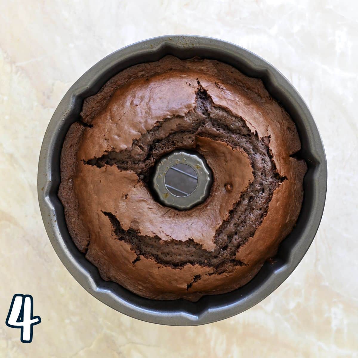 Chocolate cake in a bundt pan on a light marble surface, with a "4" in the bottom left corner.