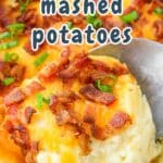 Close-up of cheesy twice baked mashed potatoes topped with bacon and chives, with a spoon lifting a portion.