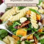 A fork holds Butternut Squash Pasta Salad with spinach, pecans, and cheese above a bowl.