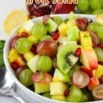 A bowl of colorful fruit salad with grapes, kiwi, and pomegranate seeds.