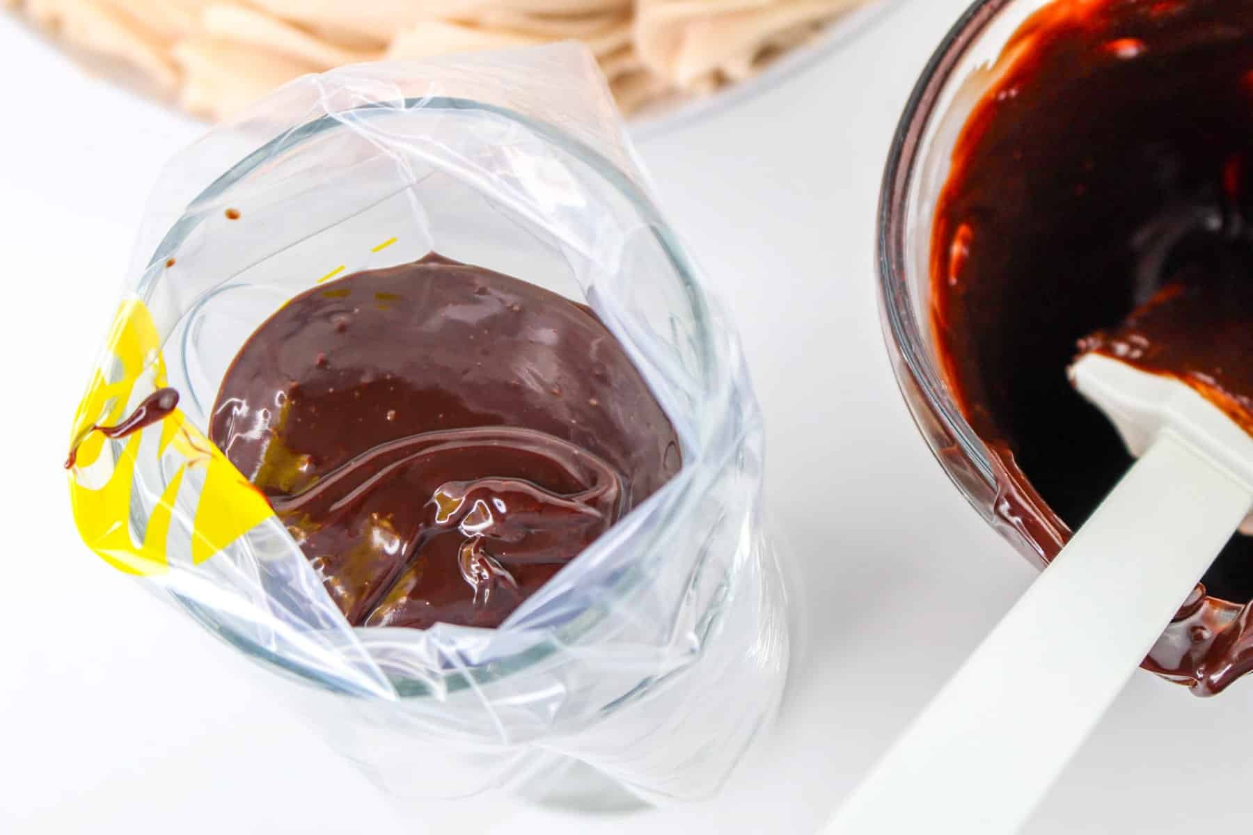 Chocolate icing being poured into a piping bag.