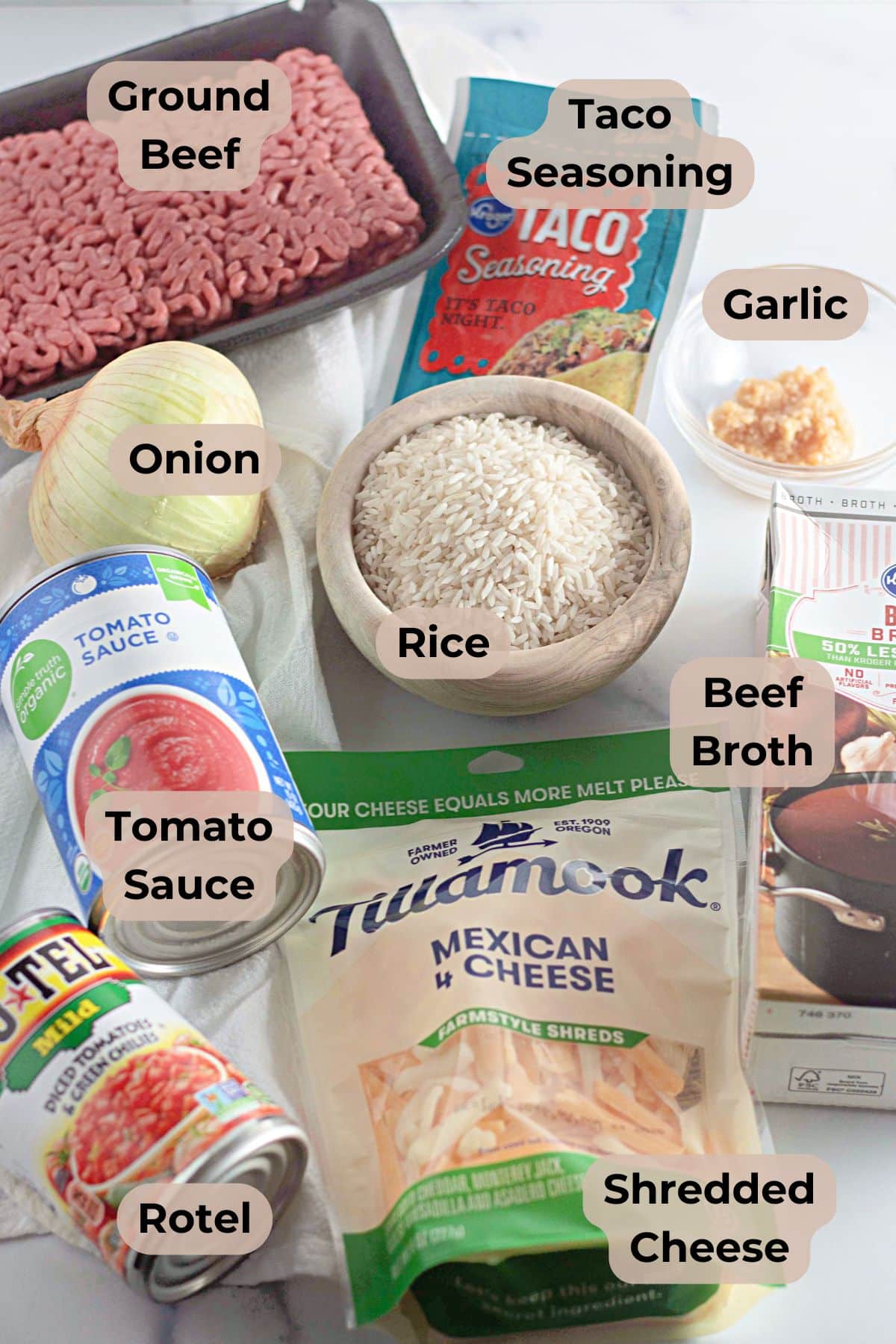 Taco Rice Skillet ingredients include ground beef, rice, onion, tomato sauce, Rotel, cheese, broth, seasoning, and garlic.
