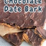 Chocolate and peanut butter date bark sprinkled with salt, displayed on a wooden board.