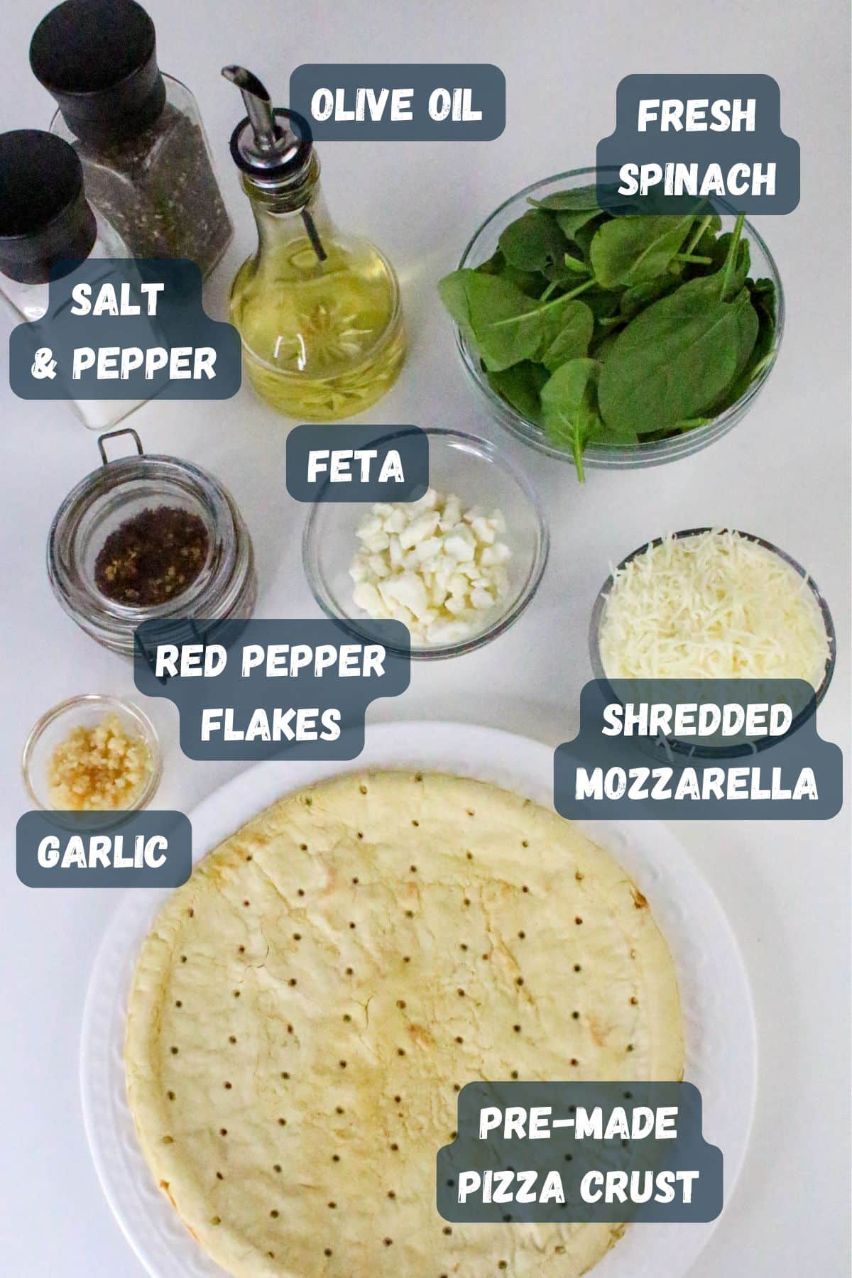 Pre-made pizza crust with ingredients: olive oil, fresh spinach, feta, mozzarella, garlic, red pepper flakes, salt, pepper.