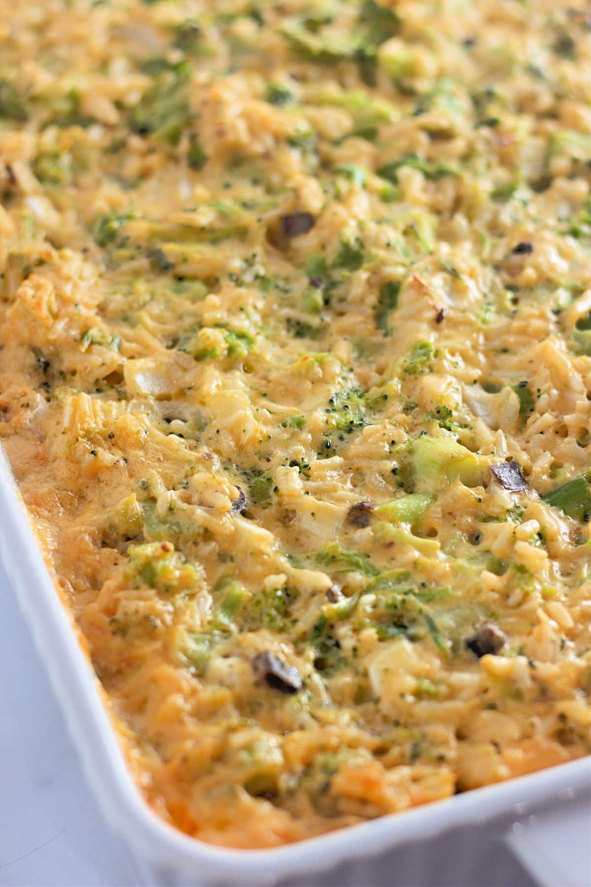 Baked casserole with broccoli, cheese, and rice in a white dish.