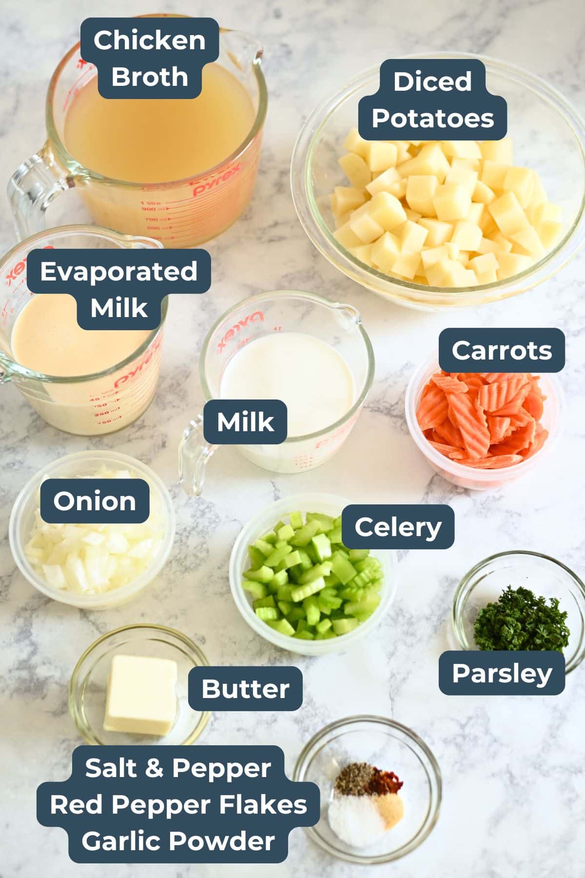 Ingredients for a soup recipe on a table, including chicken broth, diced potatoes, milk, onion, and spices.