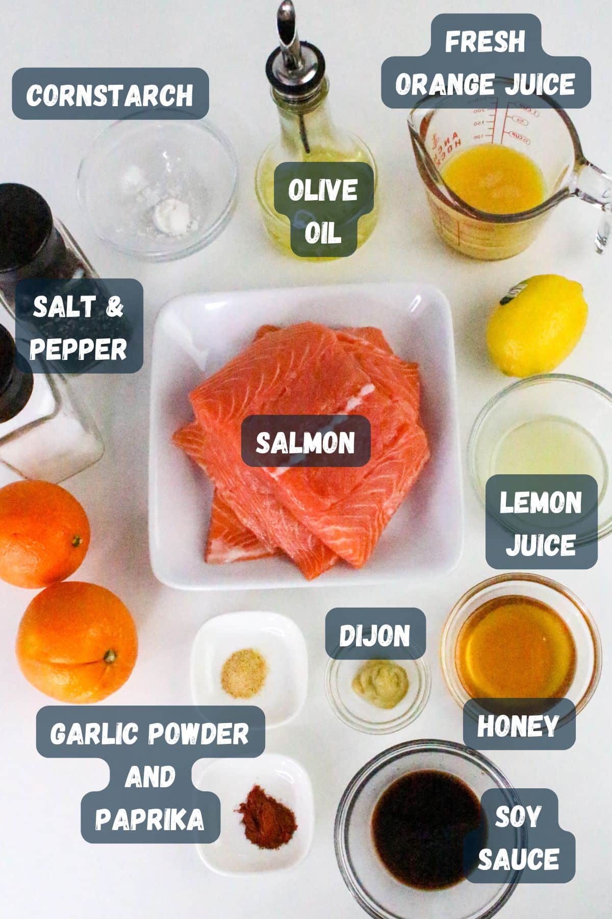 Ingredients for a salmon dish, including salmon, spices, olive oil, orange juice, honey, soy sauce, and lemon juice.