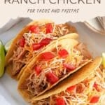 Three hard shell tacos filled with shredded ranch chicken, shredded cheese, and diced tomatoes on a white plate.
