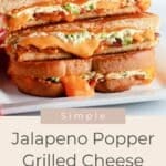 Stacked Jalapeno Popper Grilled Cheese sandwiches with melted cheese, jalapeños, and crispy bread served on a white plate.