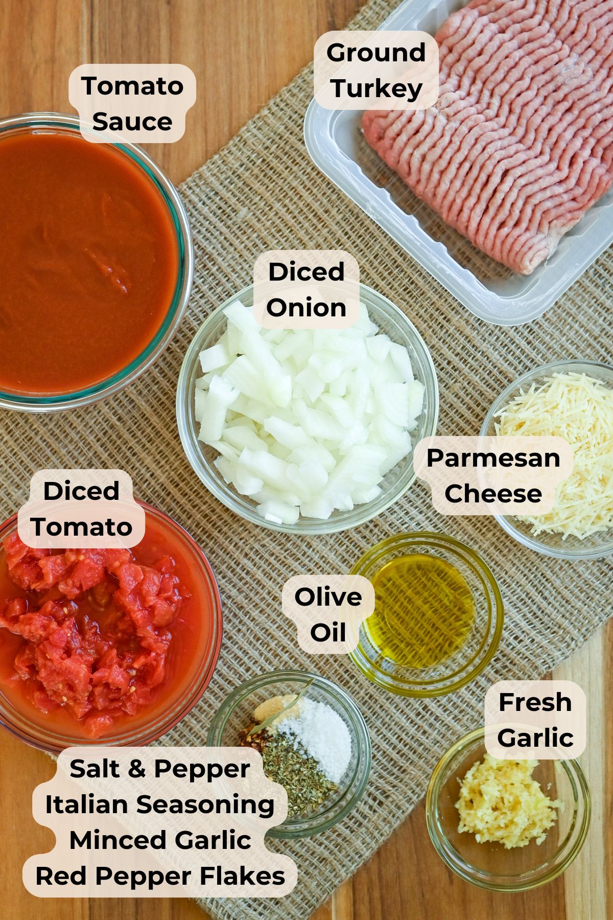 Top view of bowls with ground turkey, tomato sauce, diced onion, diced tomato, cheese, olive oil, garlic, and seasonings.