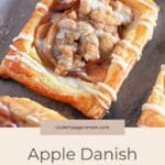 Rectangular Apple Danish pastries with crumb topping and icing drizzle rest on a baking sheet, ready to enjoy.