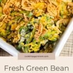 A white bowl with Fresh Green Bean Casserole, featuring green beans and cheese.