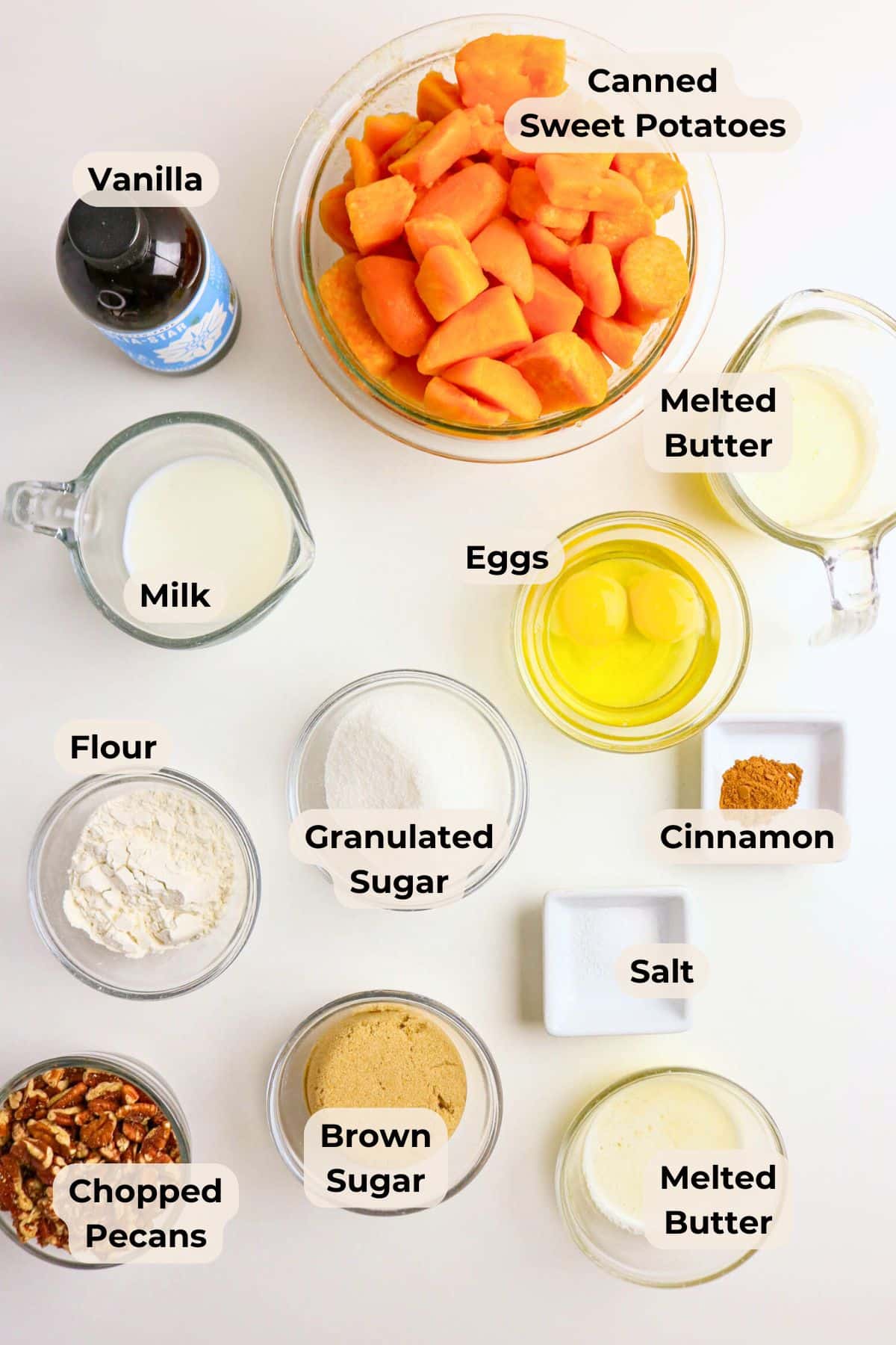 Ingredients for sweet potato casserole, including sweet potatoes, eggs, milk, sugars, spices, butter, and pecans.