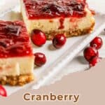 Two cranberry cheesecake bars on a plate with fresh cranberries, text reads “Cranberry Cheesecake Bars.”.