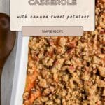 Easy Sweet Potato Casserole topped with crumbly pecan streusel in a white dish, wooden spoon on the side.