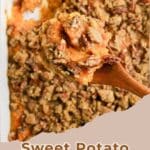A wooden spoon scoops Easy Sweet Potato Casserole with pecan topping from a baking dish.