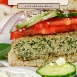 Close-up of a Spinach and Feta Turkey Burger topped with tomato, cucumber, and red onion on a bun, served with extra feta.