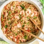 A bowl of Shrimp Yakisoba stir-fry noodles with chopped green onions, red peppers, and chopsticks on top.
