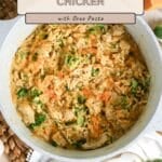 A skillet filled with Broccoli Cheddar Chicken Orzo, topped with melted cheddar and chopped parsley.