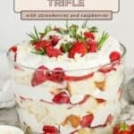 Pinterest pin graphic showing the Christmas strawberry trifle, with layered cake, pudding, and berries in a glass bowl.