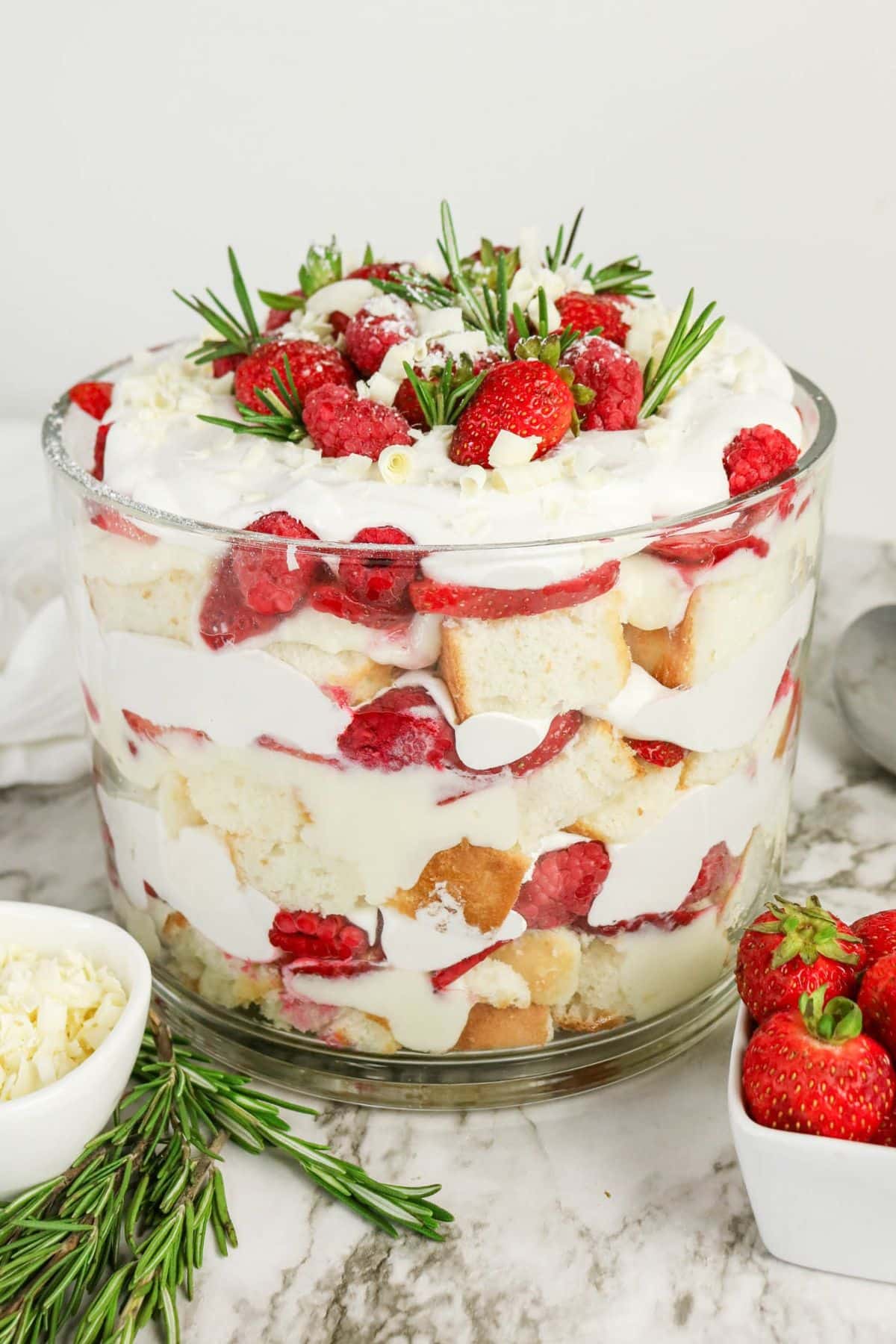 Side view of the trifle showing distinct layers of cake cubes, pudding, berries, and whipped topping.